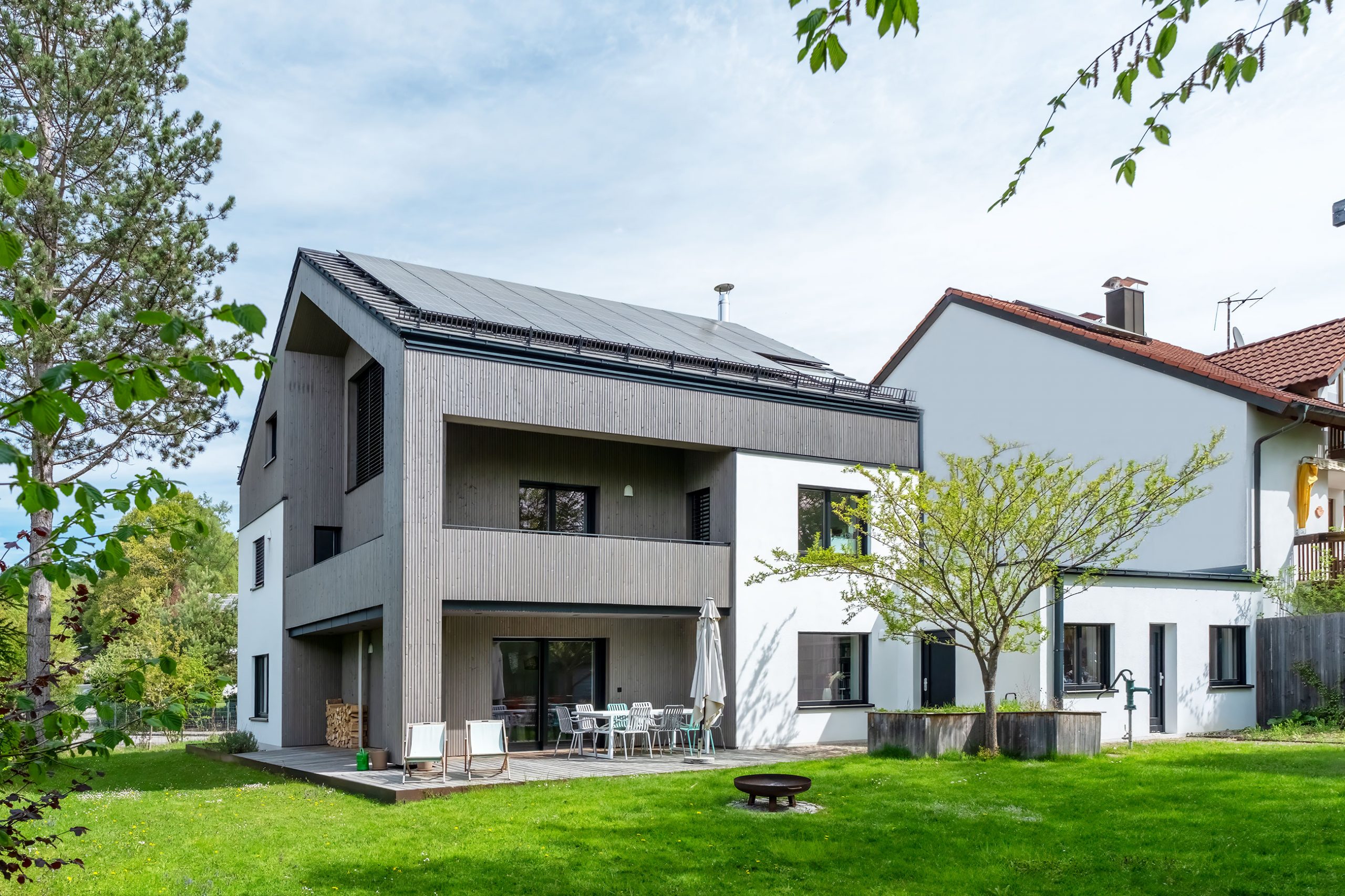 Einfamilien- & Mehrfamilienhäuser: Designer-Holzhaus mit Holzverschalung und Putzfassade